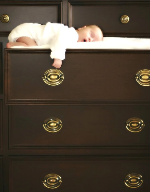 "Un tenero bambino che dorme in una cassettiera"